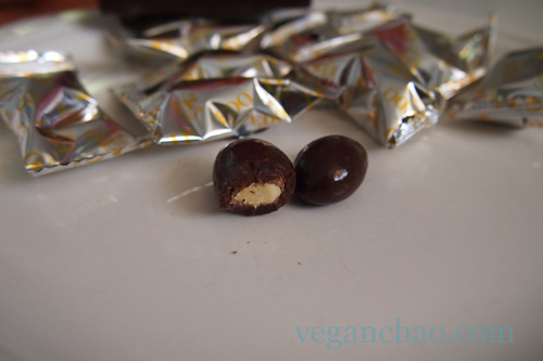 A crunchy almond is nestled inside a thick coating of glossy chocolate.
